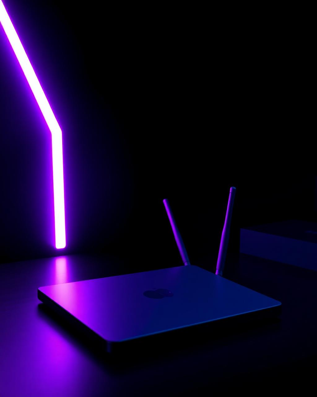 Ordinateur portable et routeur sur un bureau, éclairage bleu